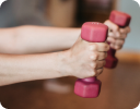 A close-up of a hand holding a pink and white object.
